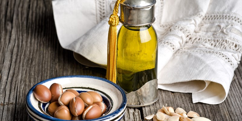 Bottle of argan oil and argan fruit. Argan oil is used for skincare products.