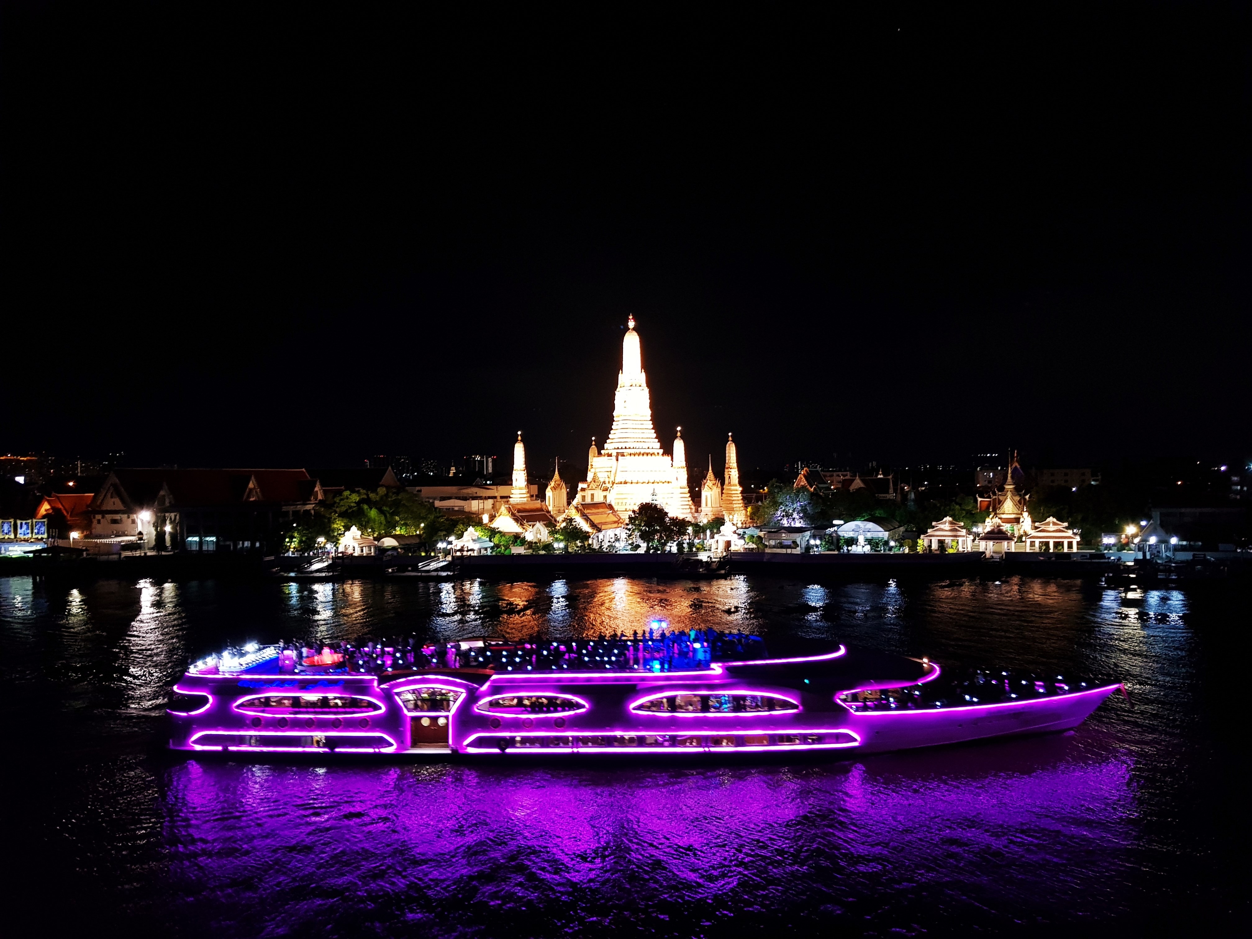 Cherry pink cruise in front of the Temple of Dawn, Chaophraya river, Bangkok