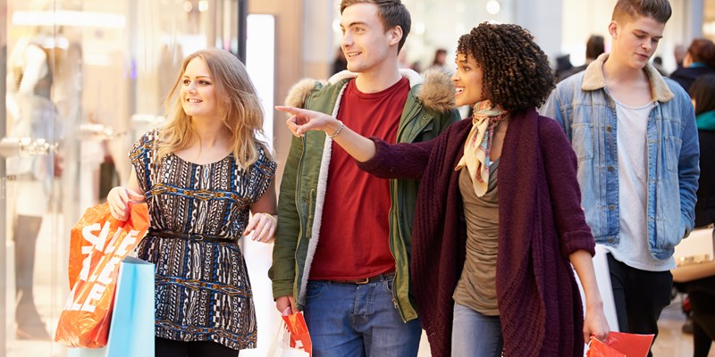 Group Of Young Friends Shopping In Mall Together