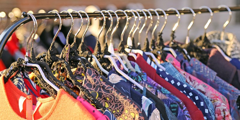Many vintage style clothes for sale at an outdoor flea market