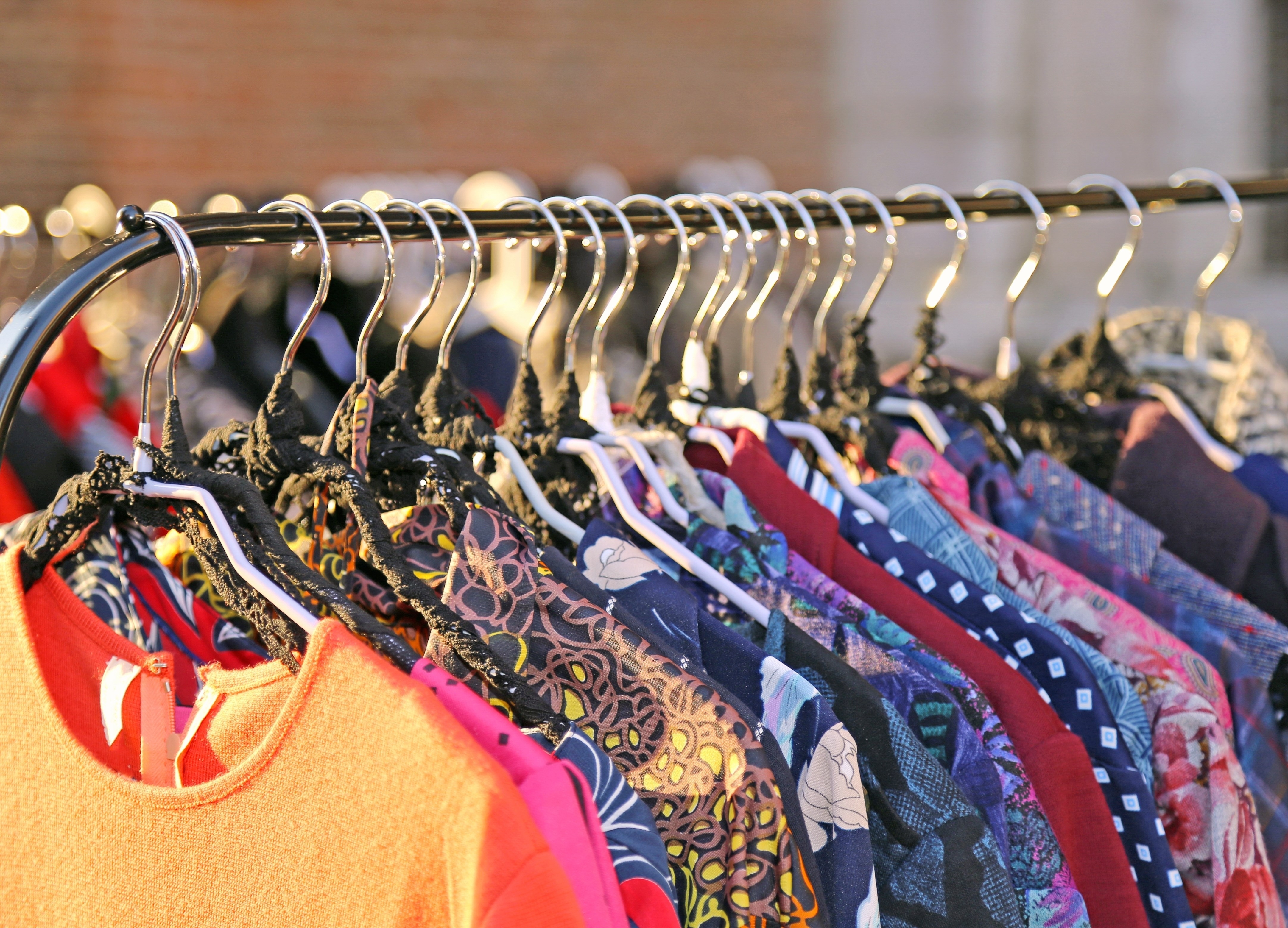 Many vintage style clothes for sale at an outdoor flea market