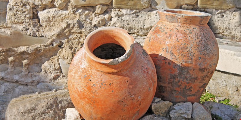 Two antique amphoras on the background of the ruins