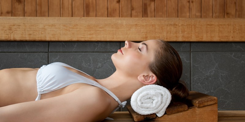 Closeup of beautiful lady relaxing at sauna in a spa center