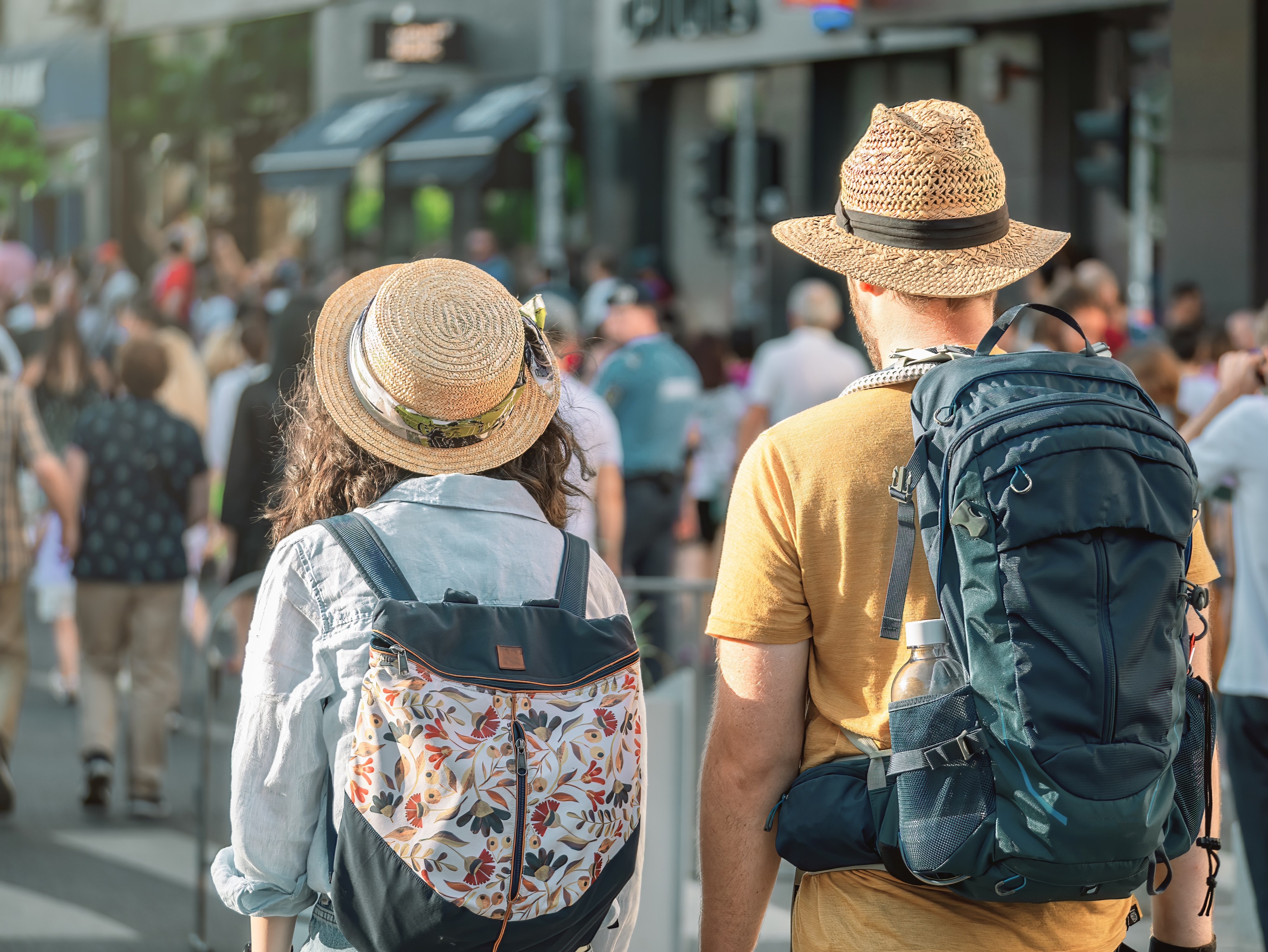 Tourist travel couple with backpacks strolling and walking on Victory street ( Calea Victoriei ). Pedestrian area in the old town of Bucharest