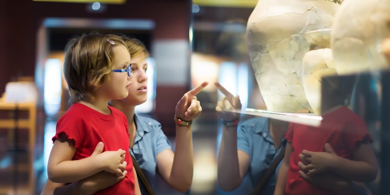 Woman and child looking old ancient amphora in historical museum