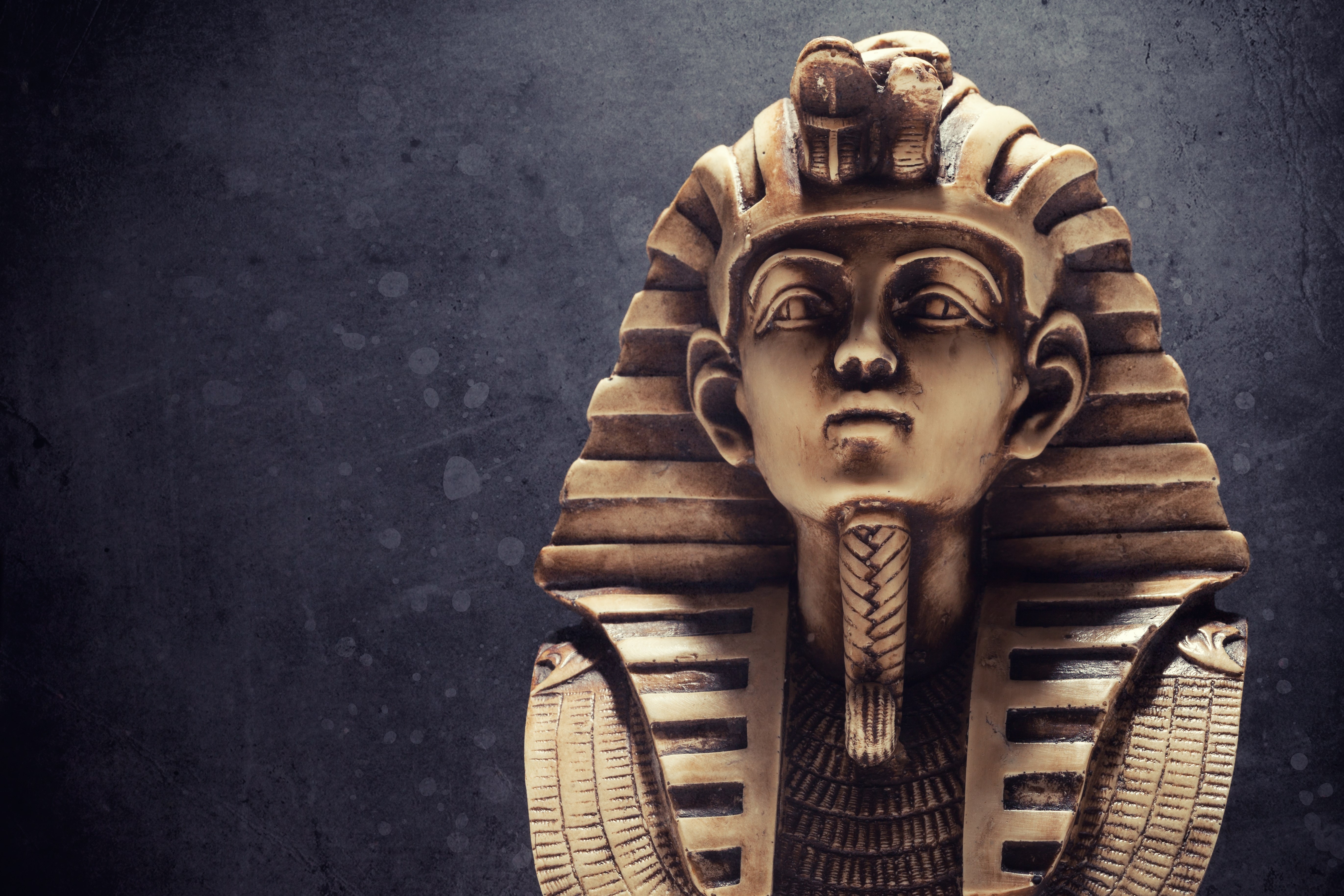 Stone pharaoh tutankhamen mask on dark background