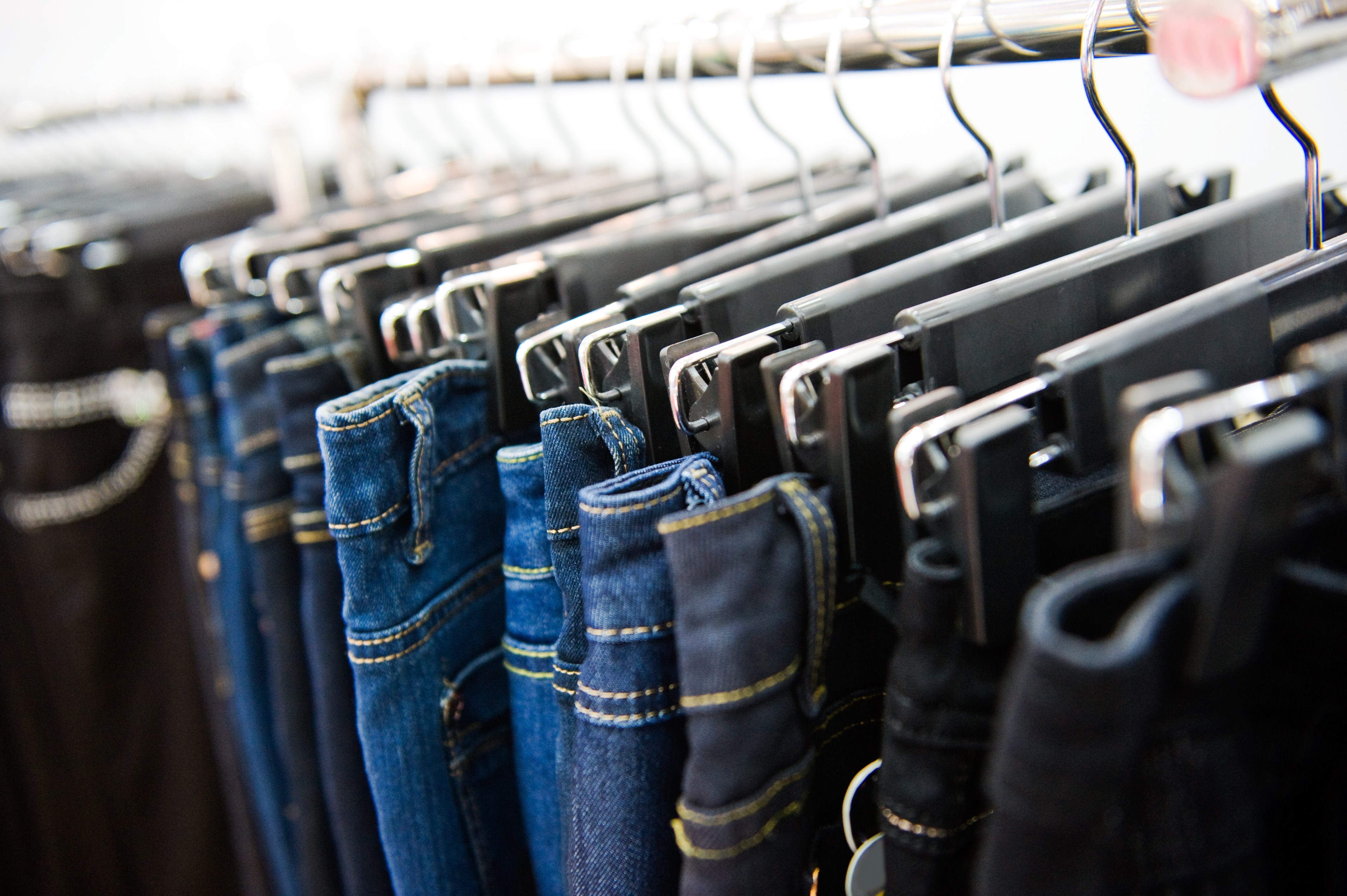 Row of hanged blue and black jeans in a shop