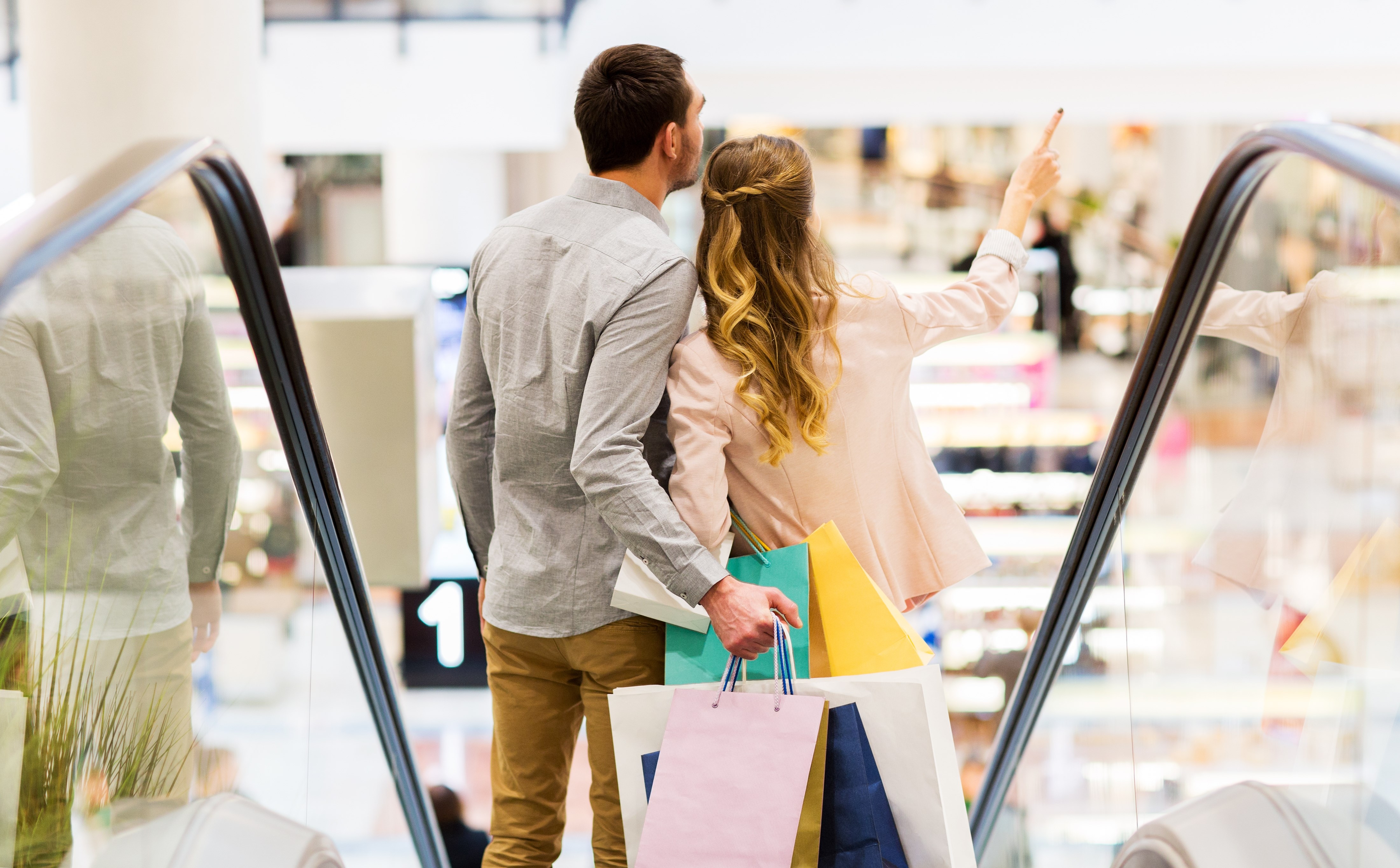 Couple going down an escalator at a department store