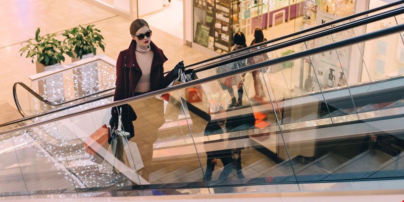 woman with shopping bags on an escalator