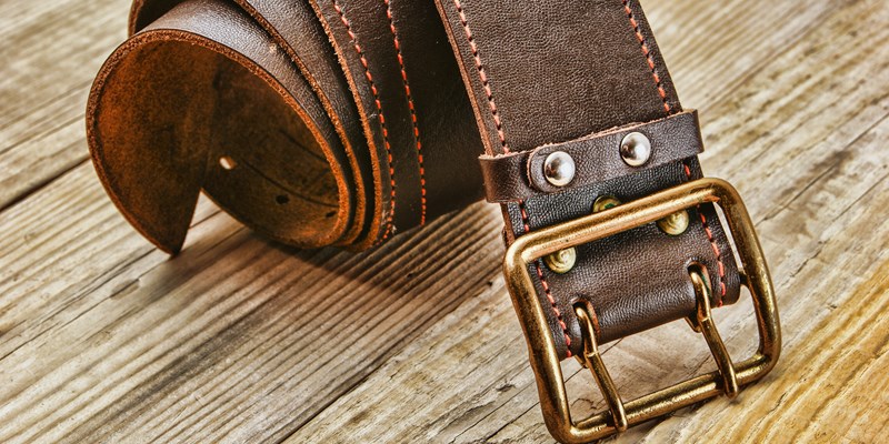 leather belt with a buckle on a wooden board