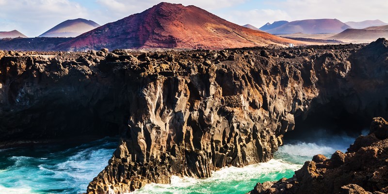 Los Hervideros, coastline in Lanzarote with waves and volcano