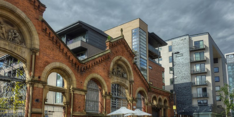 Manchester city center. Historic red brick building under a clear blue sky and fluffy clouds
