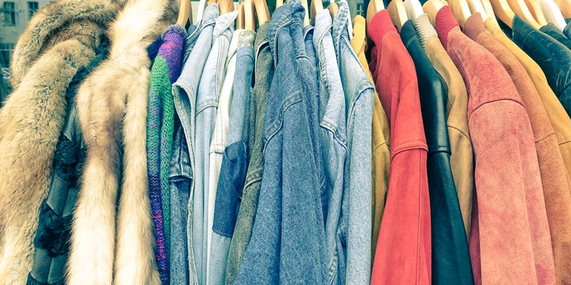 Vintage second hand clothes hanging on shop rack at weekly flea market