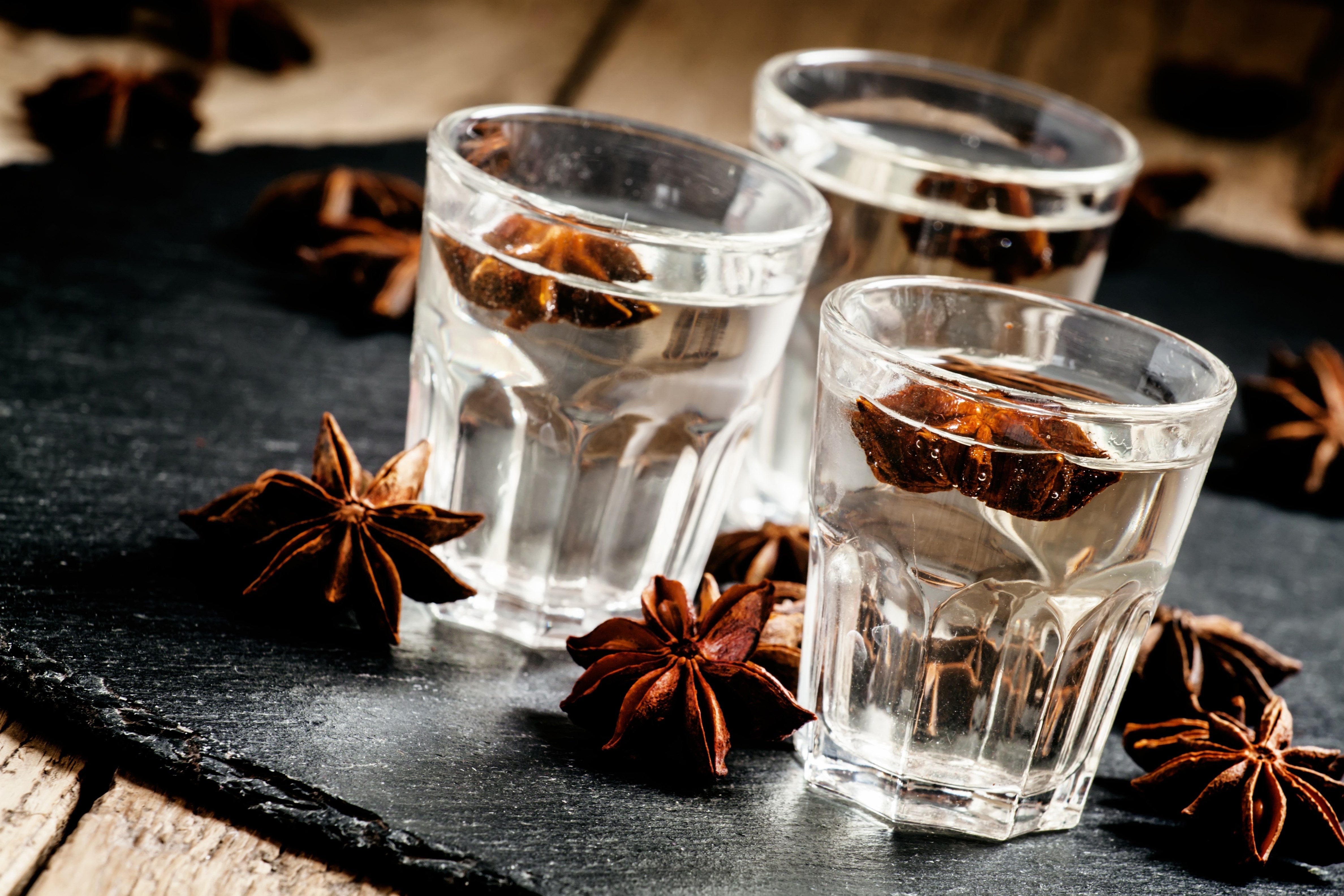 Homemade anise liqueur in a glass on a dark background