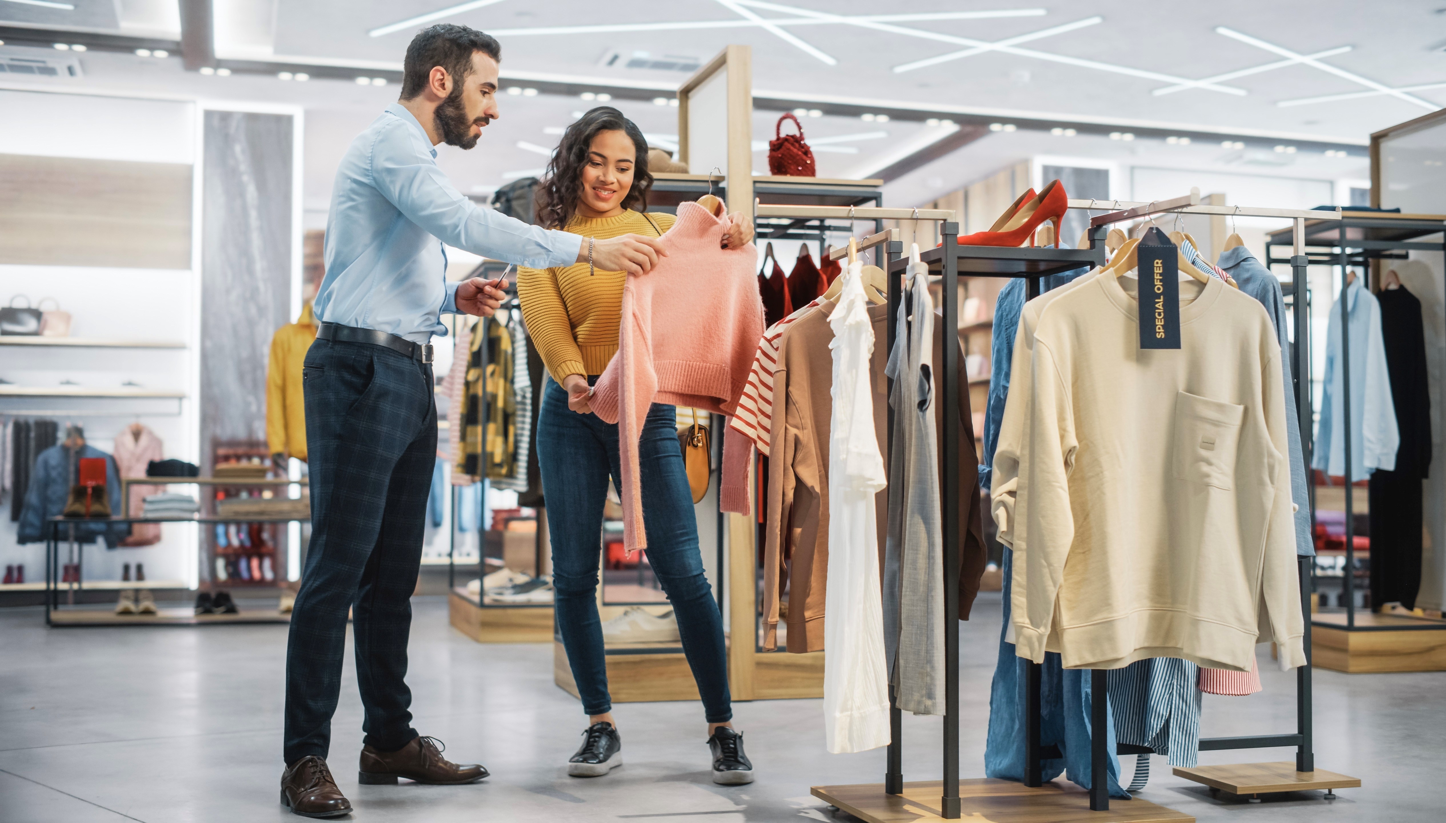 Young female customer shopping in clothing store
