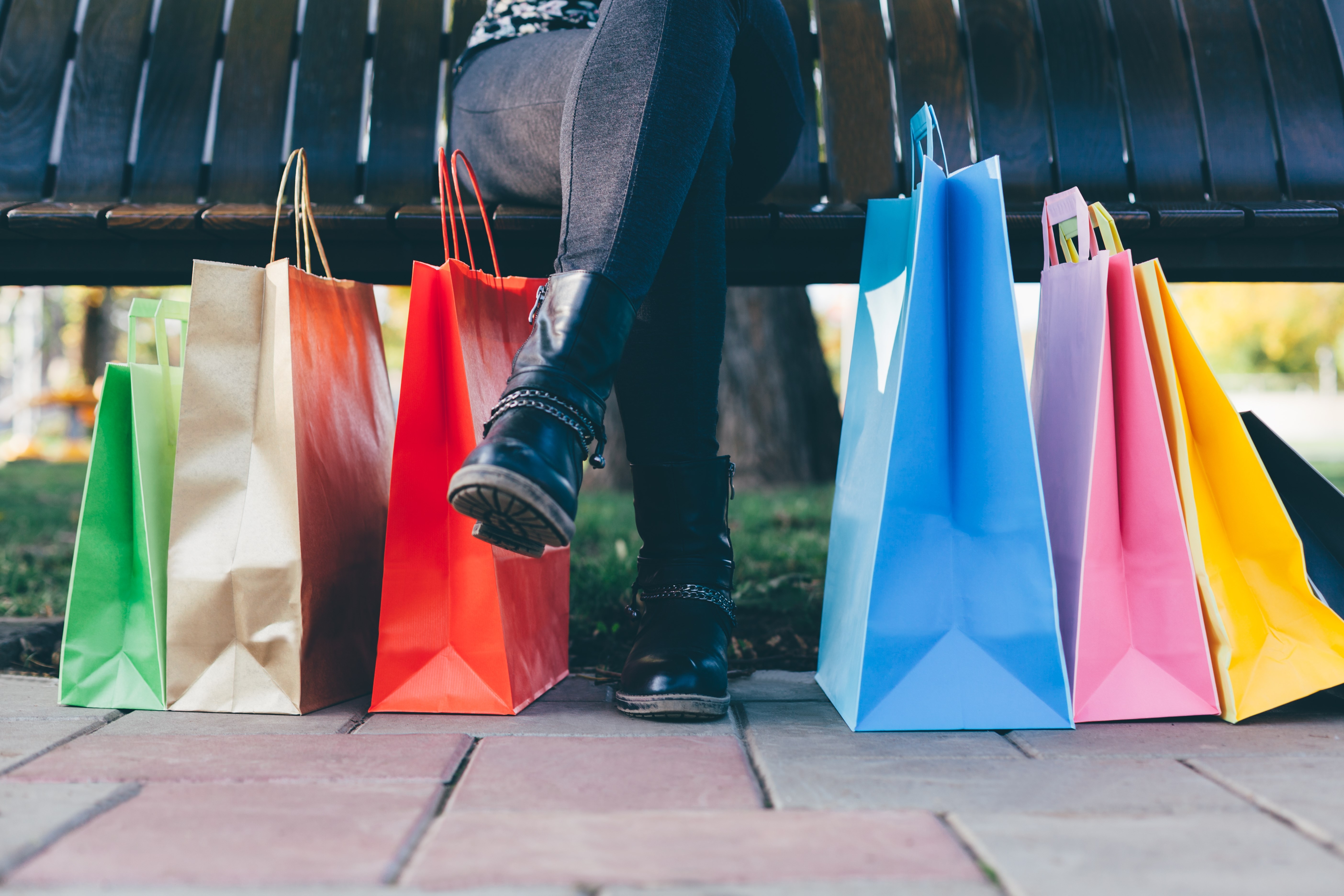 Woman sitting on bench with shopping bags, La Rinascente, Milan, Italy