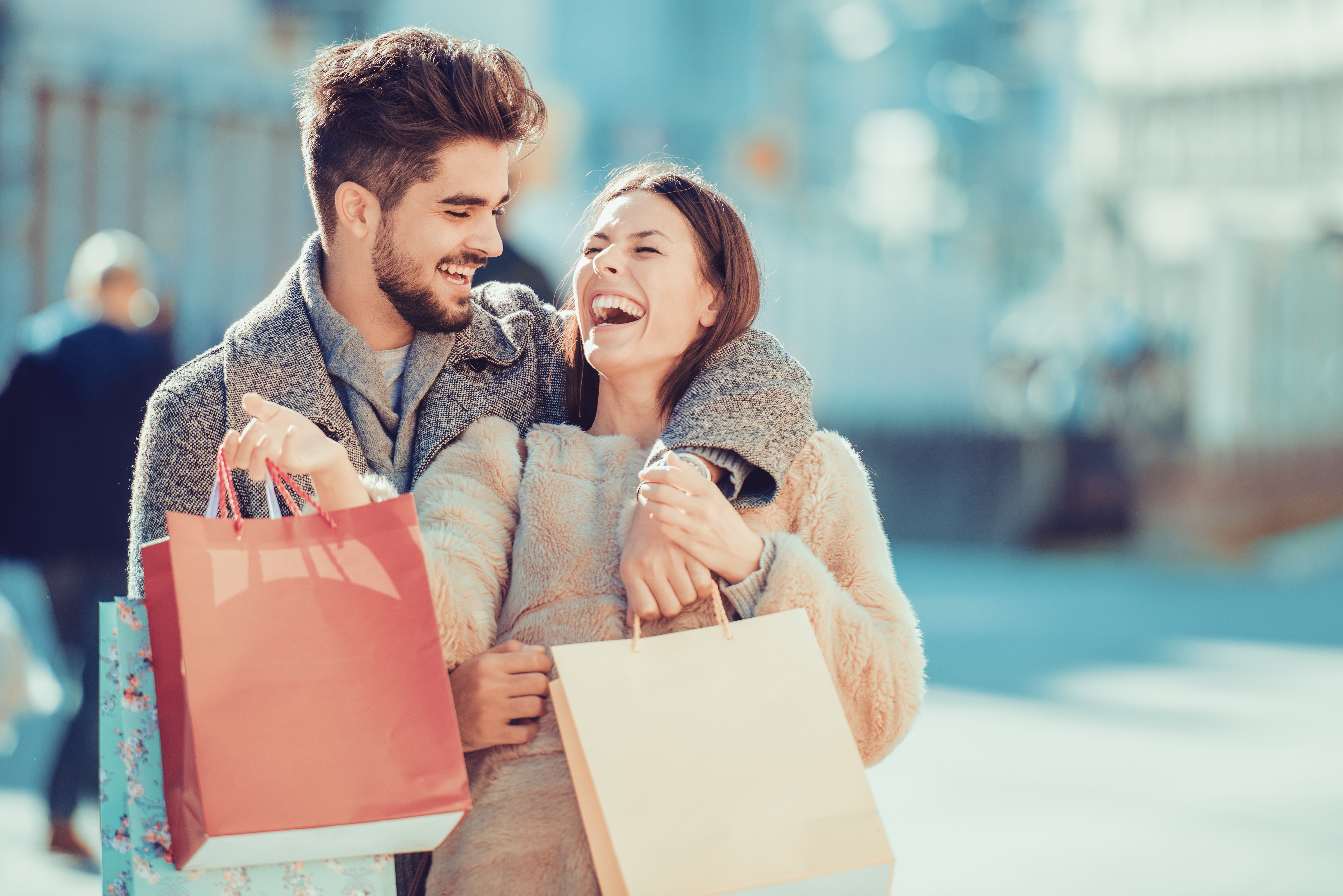 Beautiful young loving couple carrying shopping bags and enjoying together