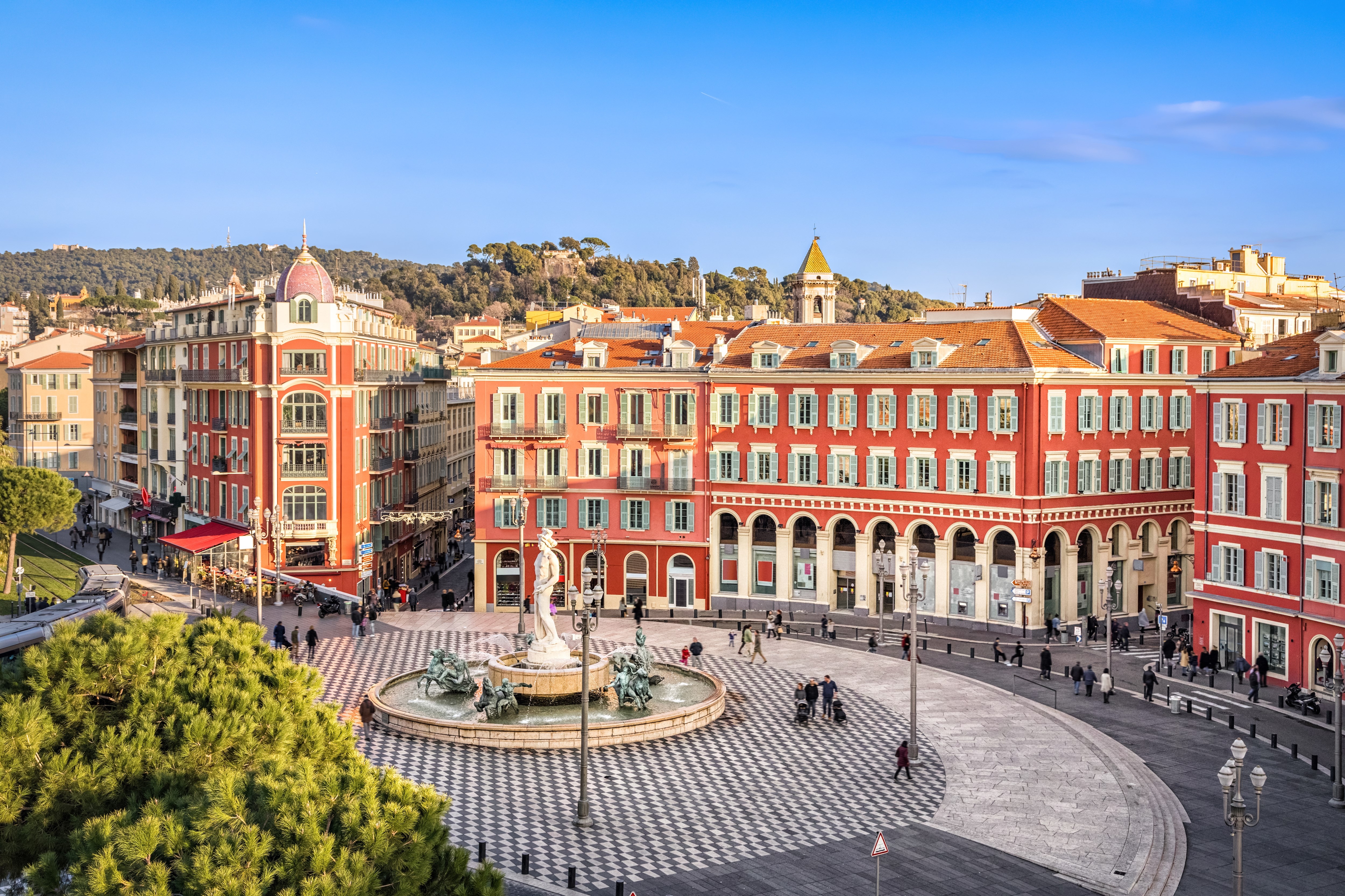 Aerial view of Place Massena square with red buildings and fountain in Nice
