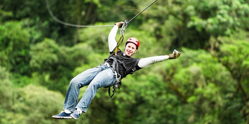 Adult Male Tourist Wearing Casual Clothing On Zip Line Or Canopy Experience In Ecuadorian Rain Forest