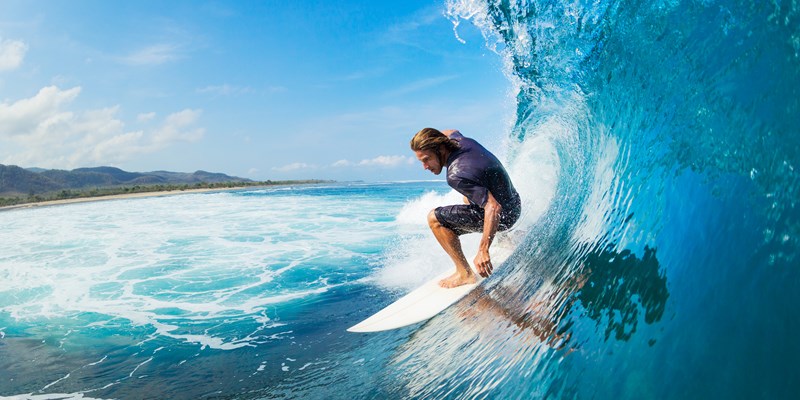 Surfer on Blue Ocean Wave in the Tube Getting Barreled