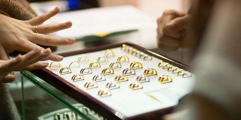 Woman trying wedding rings at a jeweller, focus on rings