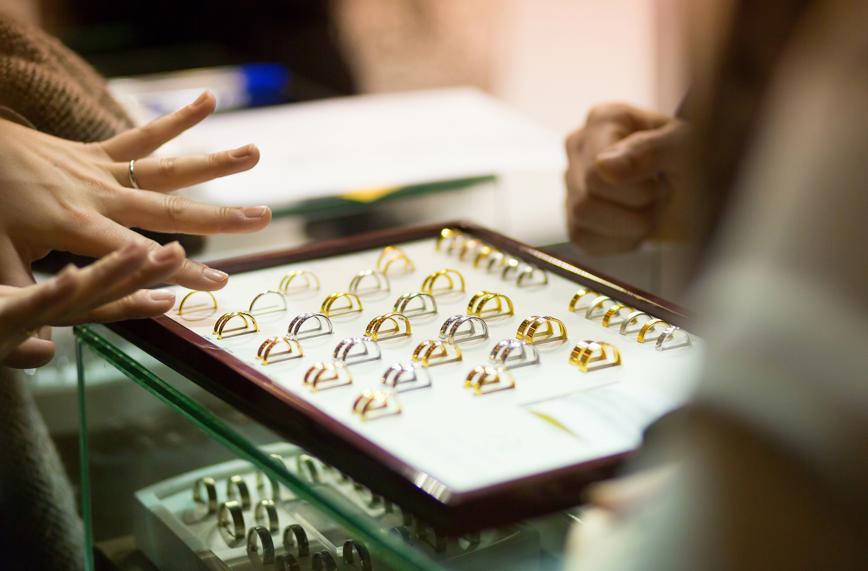 Woman trying wedding rings at a jeweller, focus on rings