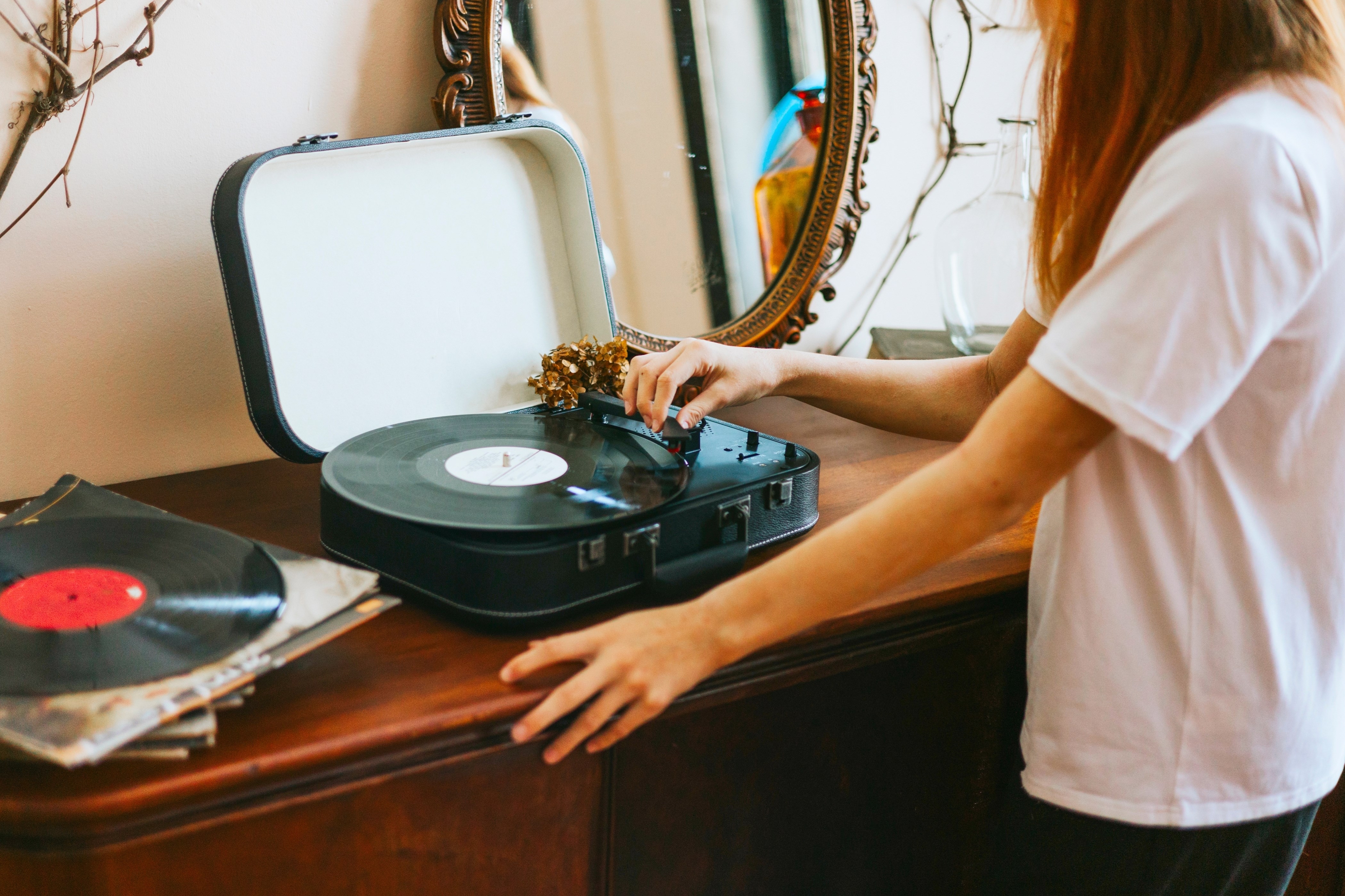 Girl turns on a retro record player, meeting modern with retro