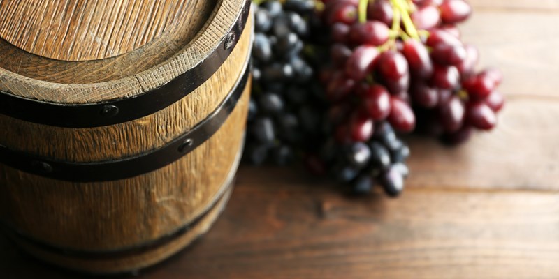 Old wine barrel and grape on wooden background