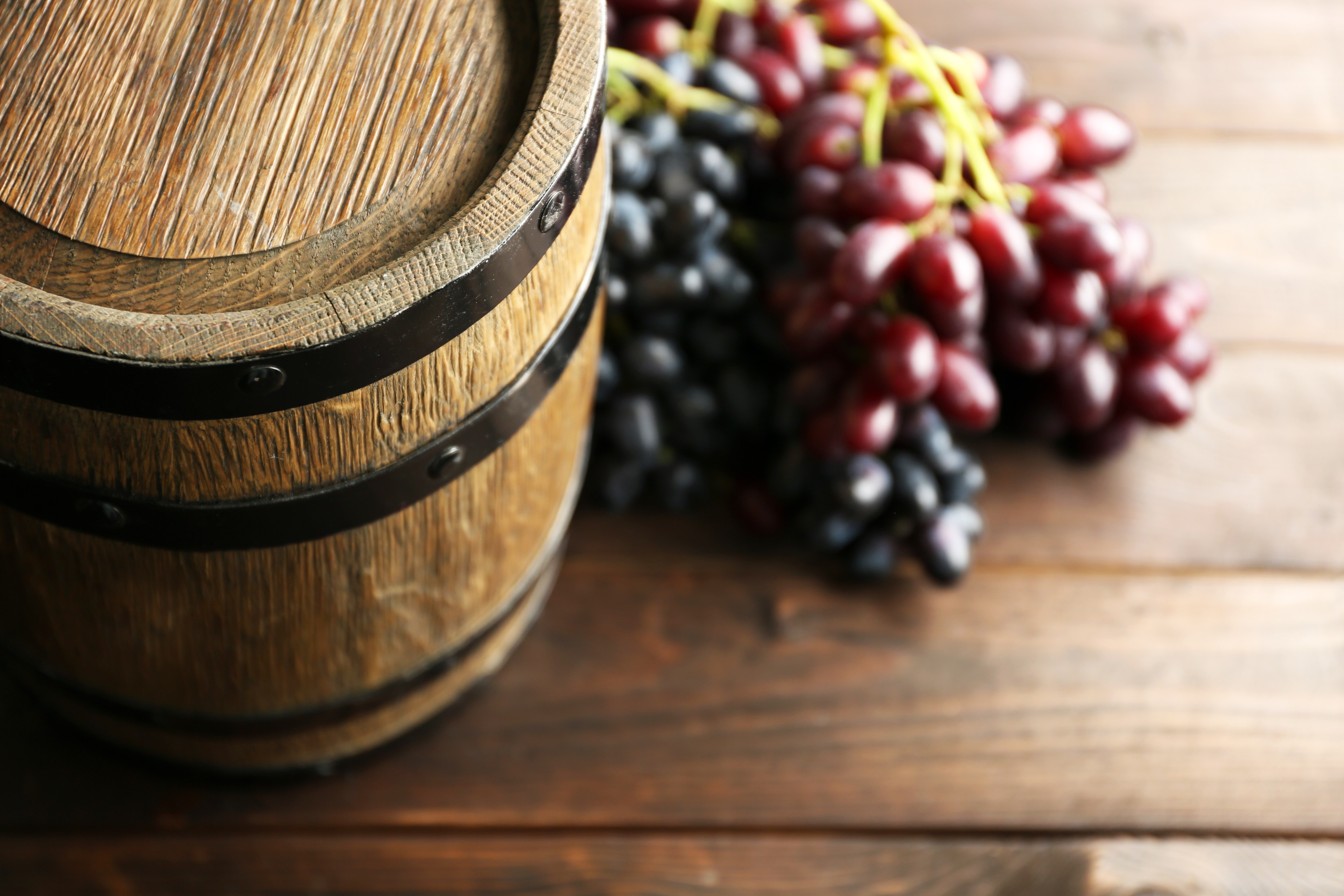 Old wine barrel and grape on wooden background