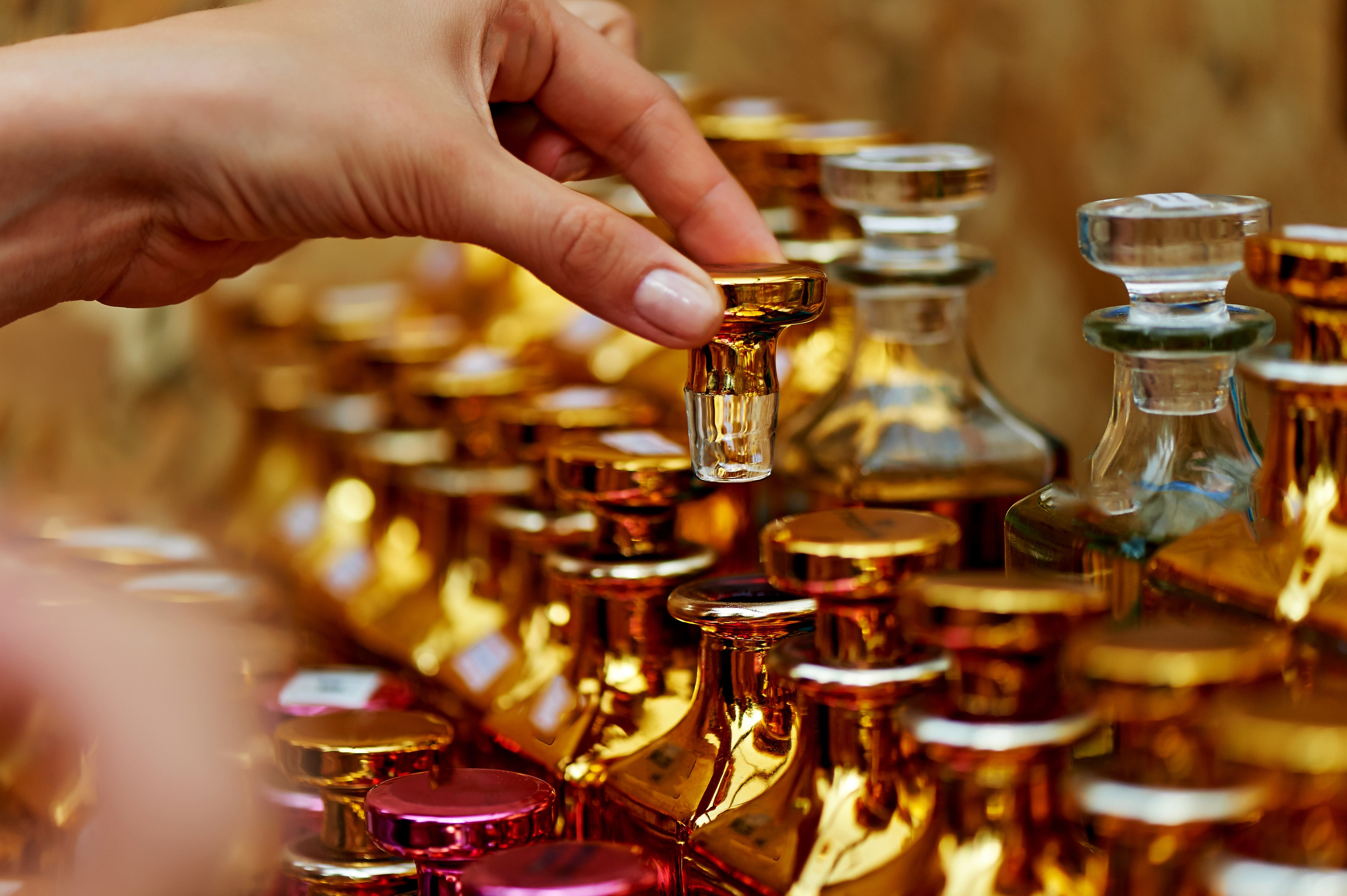 Glass perfume bottles based oils. A Bazaar, market. Macro. Gold and pink gamma