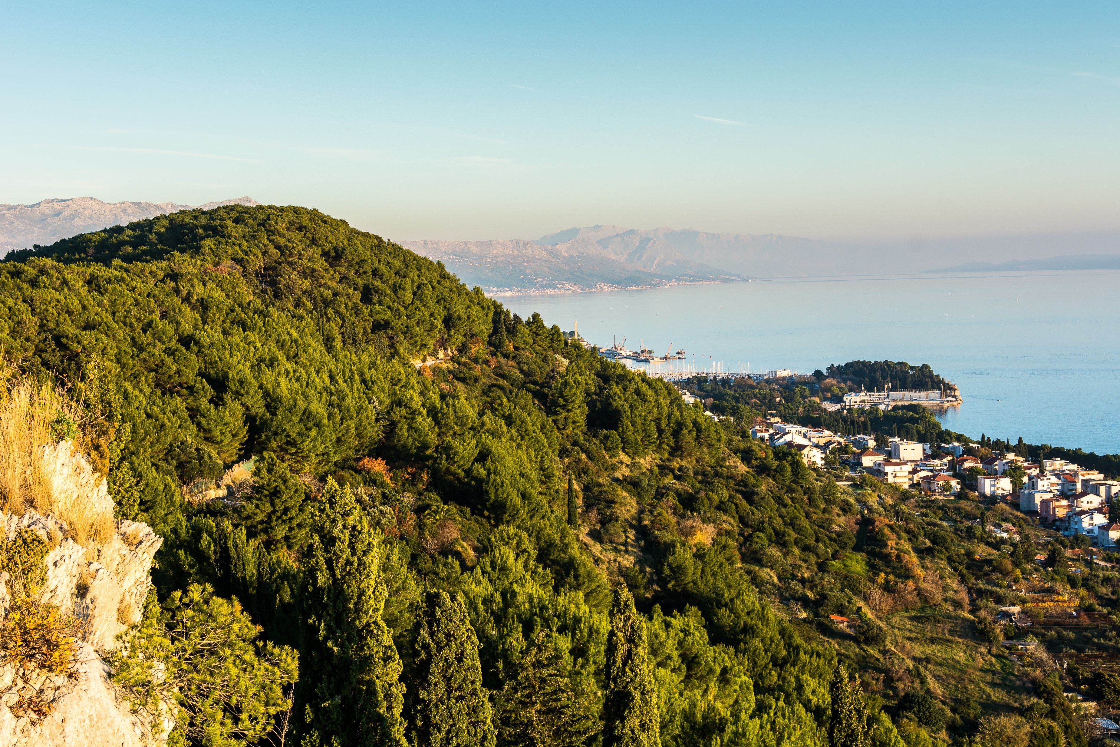 View from hill in city of Split. Split is famous because this town have a park forrest just few hundred meters from center of city. / Coastline of city Split from hill, Croatia.