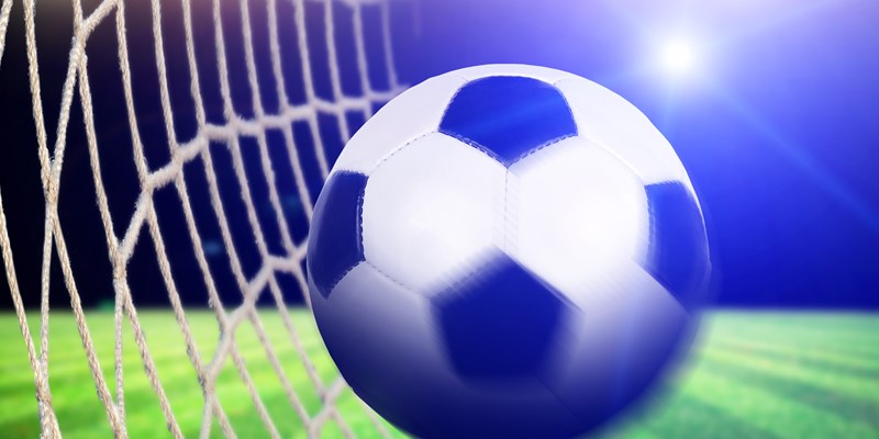 man kicking a football