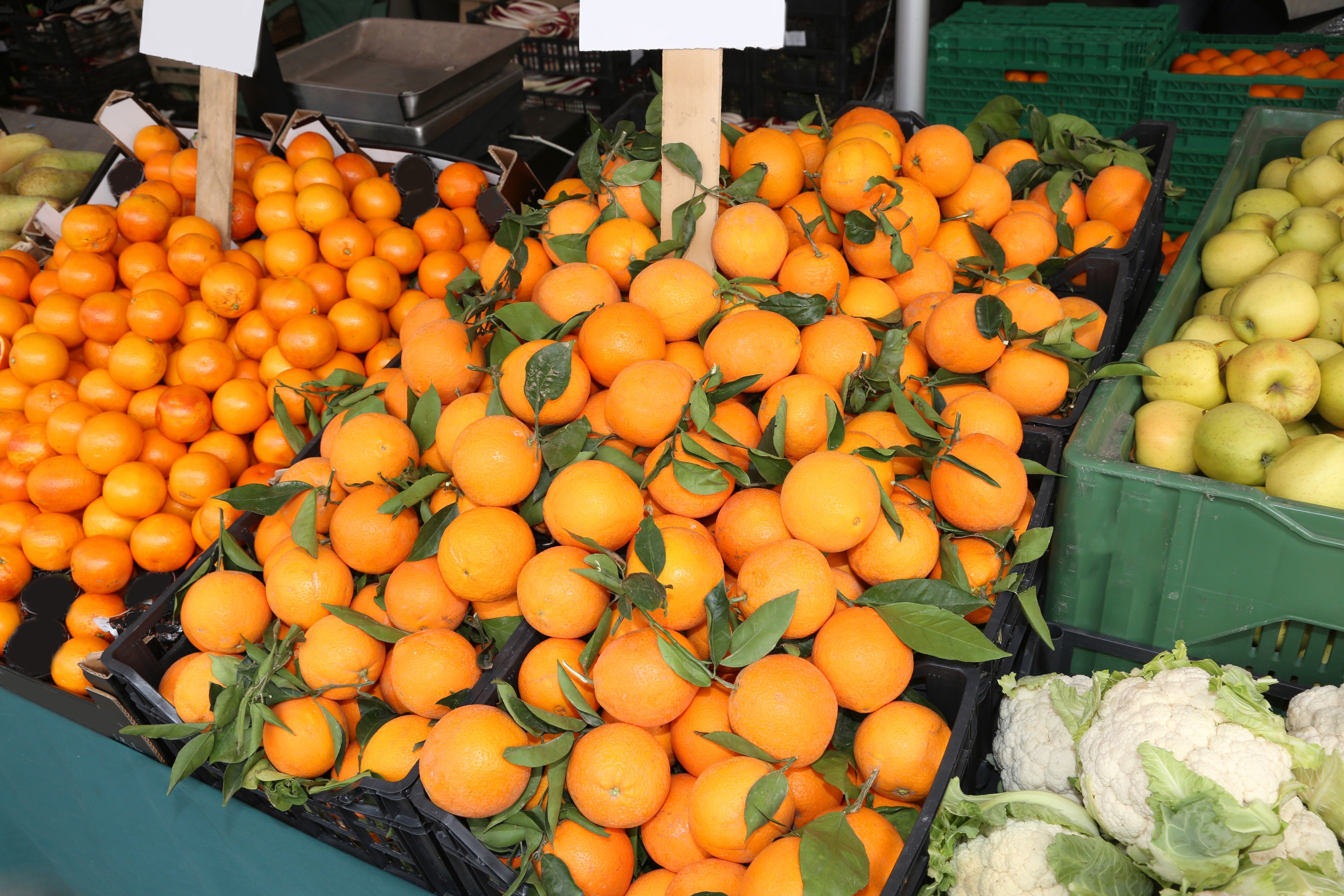 shop of greengrocer with clementines, mandarins and orange with green leaf