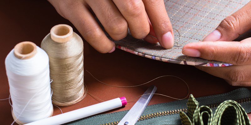 Woman's hand sewing quilt with sewing equipments
