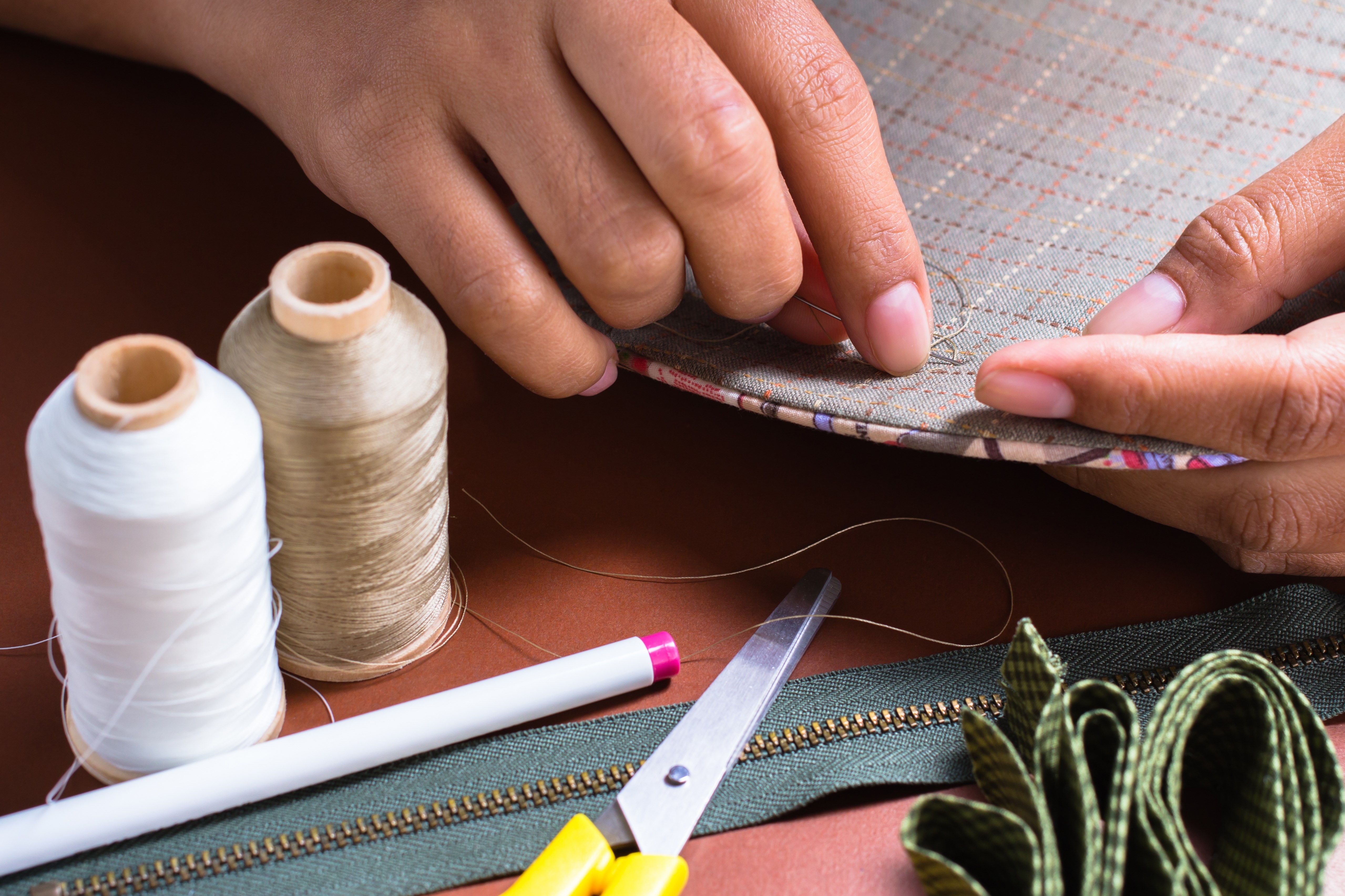 Woman's hand sewing quilt with sewing equipments