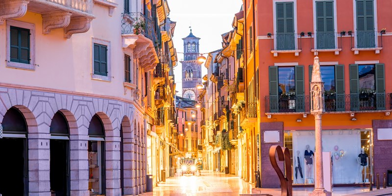 Night view on Giuseppe Mazzini famous commercial street with Lamberty tower in Verona city.