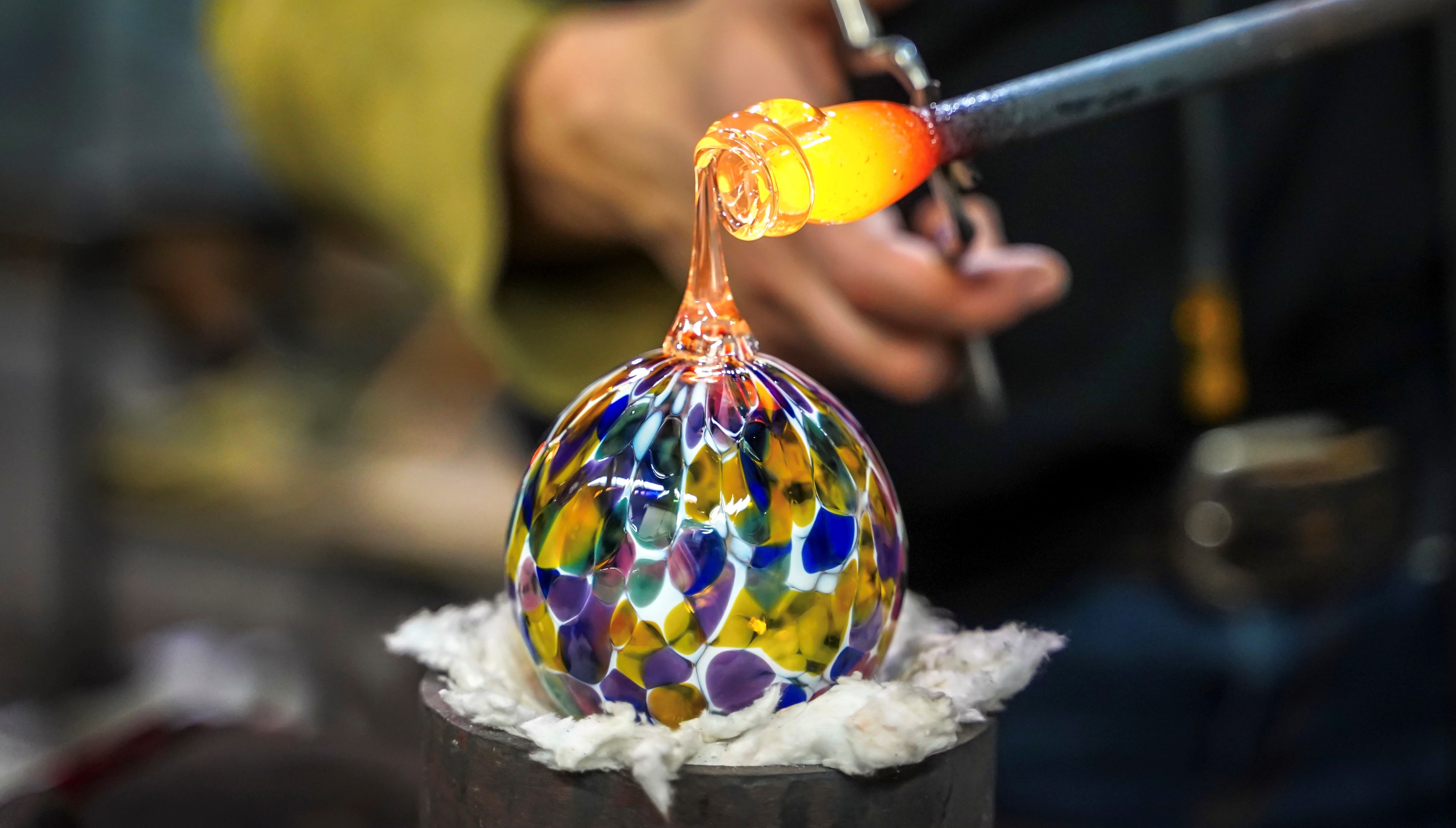 A Glass Blower Shaping Molten Glass into a Piece of Art