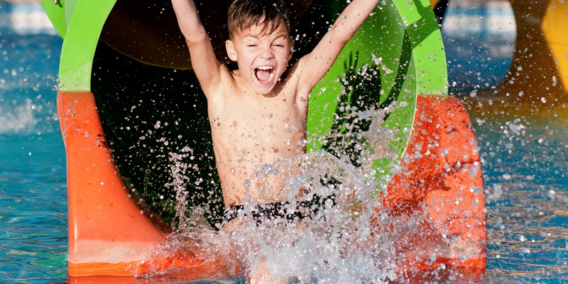 Boy has into pool after going down water slide during summer