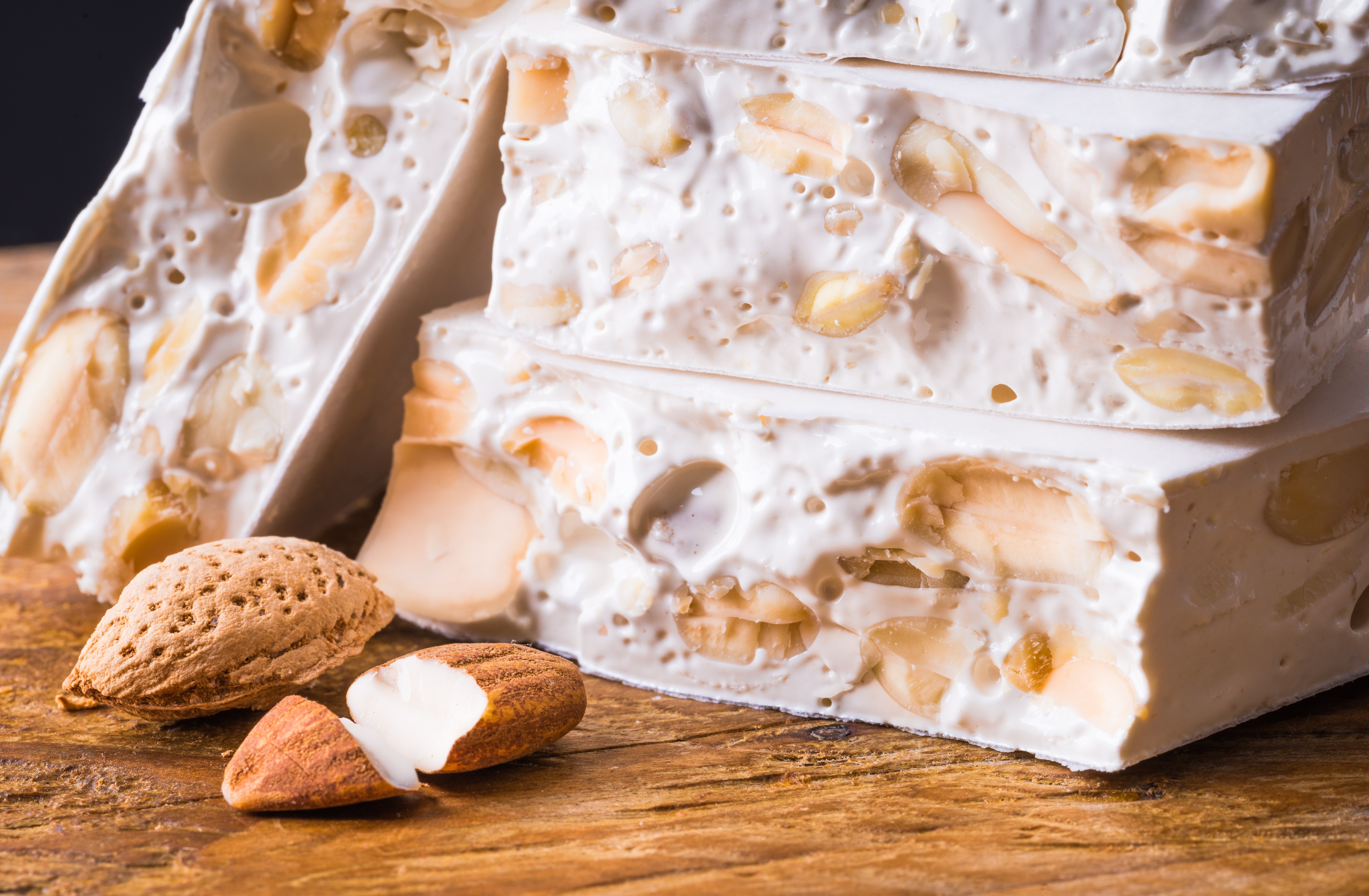 Torrone or nougat with nuts on wood background.