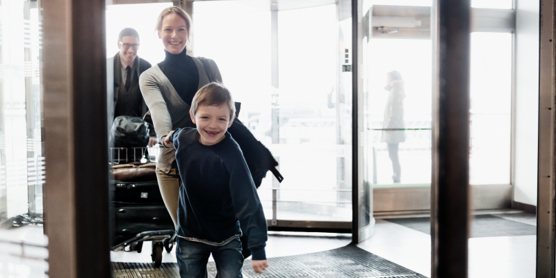 Pojke håller kvinna i handen vid ingången till terminal på Arlanda Pojke håller kvinna i handen vid ingången till terminal på Arlanda