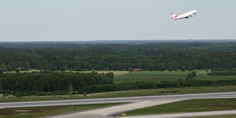 Ett flygplan har just lyft och ett taxar ut på startbanan på Arlanda Ett flygplan har just lyft och ett taxar ut på startbanan på Arlanda