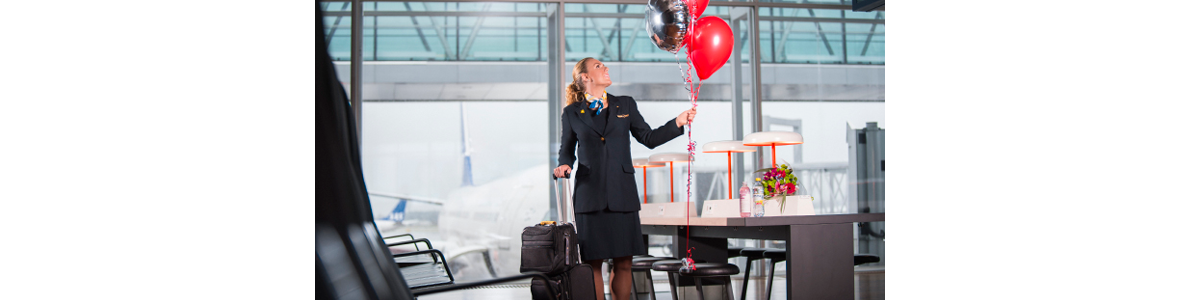 En flygvärdinna med väskor och ballonger En flygvärdinna med väskor och ballonger