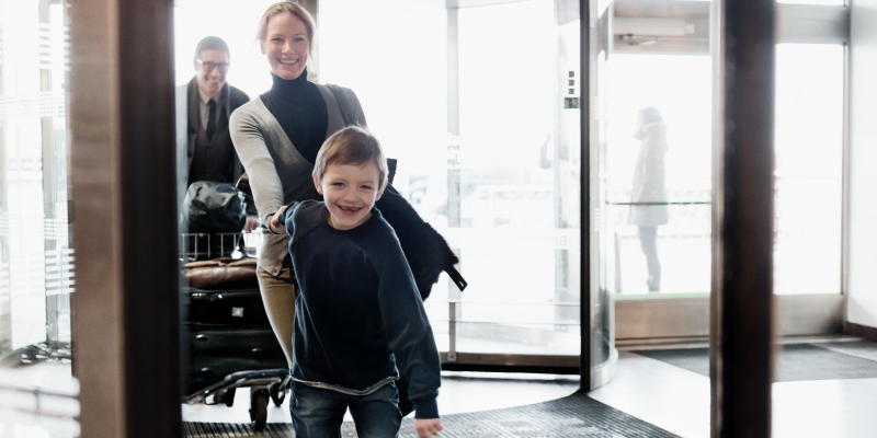 Pojke håller kvinna i handen vid entré till Terminal 5 Pojke håller kvinna i handen vid ingången till terminal på Arlanda