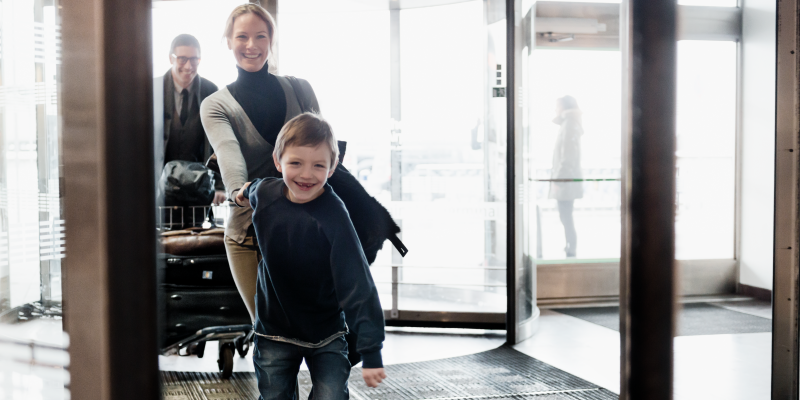 Pojke håller kvinna i handen vid ingången till terminal på Arlanda Pojke håller kvinna i handen vid ingången till terminal på Arlanda