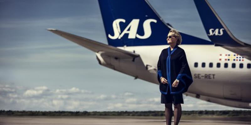 En SAS-anställd framför ett SAS-plan på landningsbana En SAS-anställd framför ett SAS-plan på landningsbana