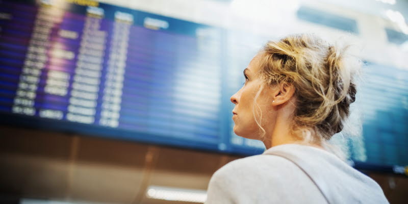 En person tittar på tavla med avgångar eller ankomster på Arlanda En person tittar på tavla med avgångar eller ankomster på Arlanda