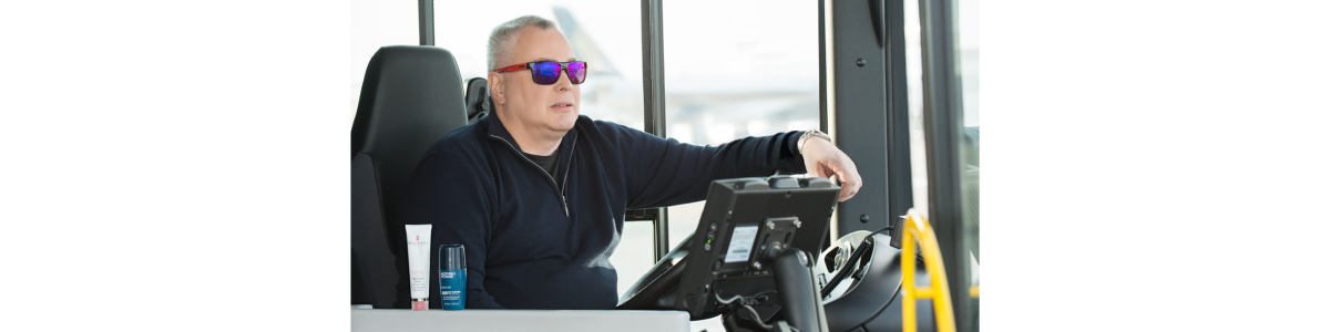 En man med solglasögon kör en buss En man med solglasögon kör en buss