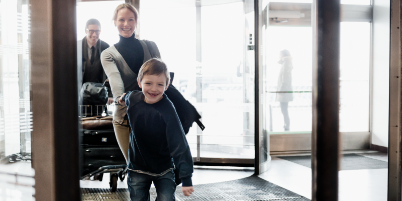 En förväntansfull familj går in på flygplatsen En förväntansfull familj går in på flygplatsen