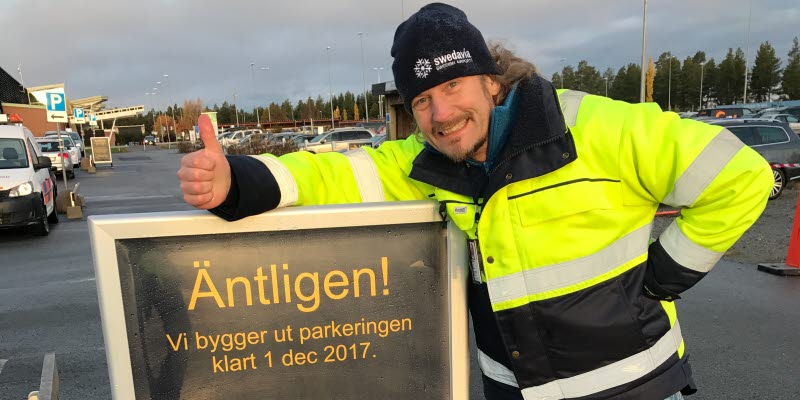 En bild på en person vid en skylt om utbyggnad av parkering En bild på en person vid en skylt om utbyggnad av parkering