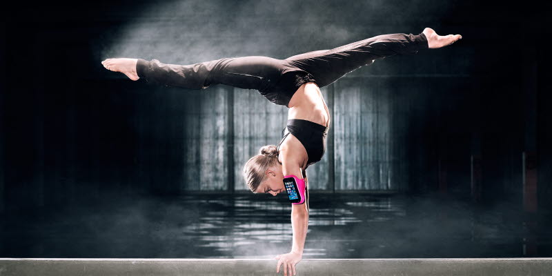 Gymnast i split med telefon på armen Gymnast i split med telefon på armen